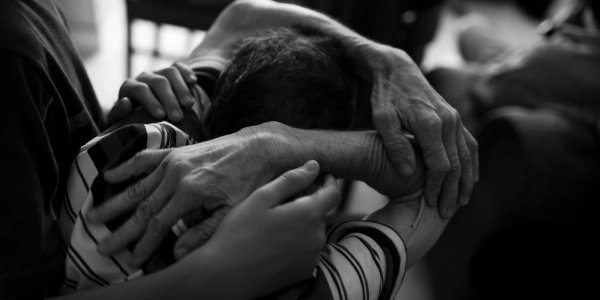 A man with early signs of Alzheimer’s disease in Medellín, Colombia, being comforted by his son.