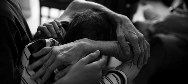 A man with early signs of Alzheimer’s disease in Medellín, Colombia, being comforted by his son.
