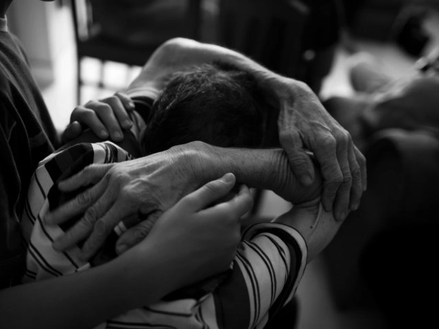 A man with early signs of Alzheimer’s disease in Medellín, Colombia, being comforted by his son.